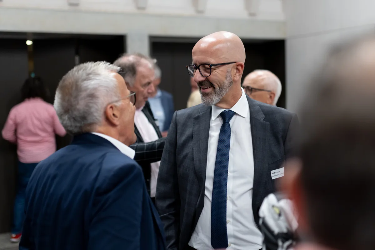 Mehrere Personen stehen zusammen und diskutieren. 